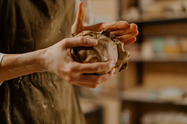 陶芸のワークショップのマスターは ツールの間でテーブルの上に彼の手で粘土を混練 — ストック写真