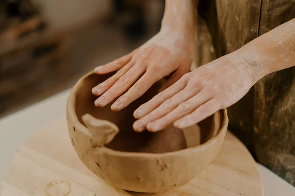 陶磁器工房の職人の手で粘土で作られた粘土料理で作られた完成品 — ストック写真