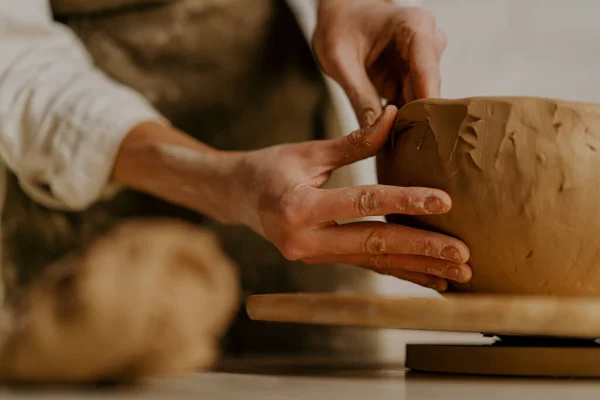 陶芸のワークショップでは マスターはテーブルの上に彼の手で粘土料理を彫刻 — ストック写真