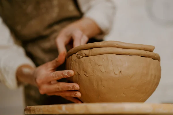陶芸のワークショップでは マスターはテーブルの上に彼の手で粘土料理を彫刻 — ストック写真