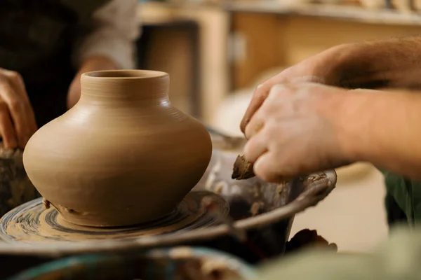 陶芸工房の陶芸家は 陶芸家のナイフで陶芸家のホイールからジャグを削除します — ストック写真