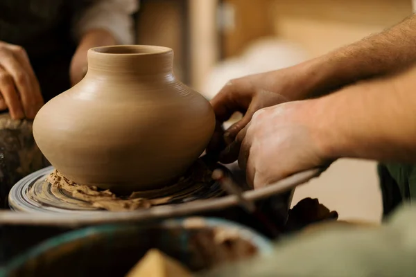 陶芸工房の陶芸家は 陶芸家のナイフで陶芸家のホイールからジャグを削除します — ストック写真