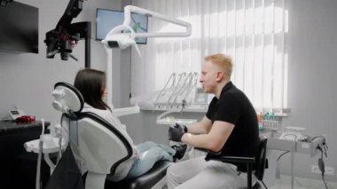 Diş hekimi hastası bir dişçiyle görüşüyor.