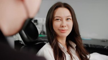 Diş hekimindeki bir diş hekimi hastaya dişlerini nasıl fırçalayacağını söyler.