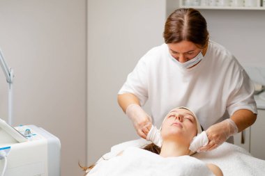 Bir kozmetik kliniğinde yüz hastasının cildini gençleştirmek için estetik ameliyat. Güzellik prosedürü uyguluyor.