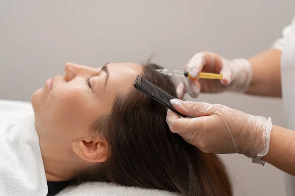 stock image A beautician makes injections into the scalp for hair growth Mesotherapy for hair growth and strengthening in beauty salon A procedure against hair loss