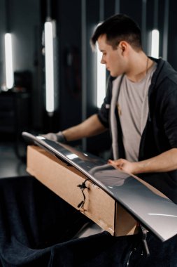 Araba spoiler 'ı boyayı çiziklerden ve araba temizleyicisinden koruyan bir boya koruması filmine yapıştırmak için hazırlamak