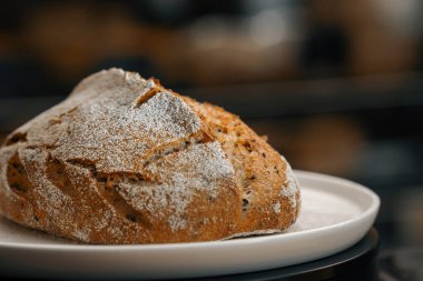 Yakın plan, fırın. Dönen yüzeyde taze pişmiş siyah ekmek.