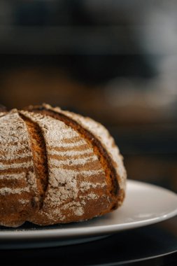 Yakın plan, fırın. Dönen yüzeyde taze pişmiş siyah ekmek.