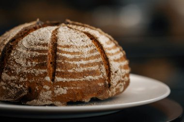 Yakın plan, fırın. Dönen yüzeyde taze pişmiş siyah ekmek.