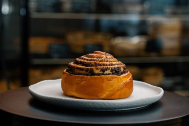 Yakın plan, fırın - haşhaş tohumu topuzu dönen yüzeyde