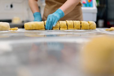 Fırındaki mutfak - tarçın yapma işlemi, kadın fırıncı hamuru kesiyor.