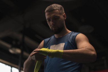 Erkek boksör, Genç Sporcu 'daki dövüşten önce kollarını sıvadı. Yakın plan spor kavramına hazırlanıyor.