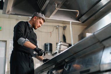 Otel restoranında profesyonel mutfak bıçaklı şef sebze burgeri keser.