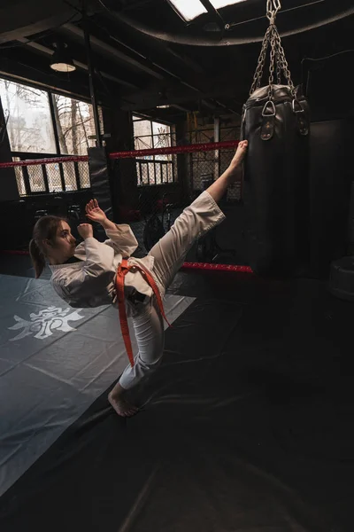 Dziewczyna Kimono Ćwiczy Workiem Treningowym Siłowni Podczas Nauki Karate Martial — Zdjęcie stockowe