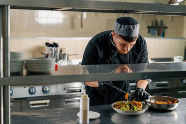 Otel şefinin restoranındaki profesyonel mutfak deniz ürünleri salatası hazırlıyor.