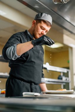 Otel şefinin restoranındaki profesyonel mutfak taze pişmiş somona limon sıkıyor.