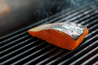 Bir otel restoranında profesyonel bir mutfak. Izgarada taze somon balığı var.