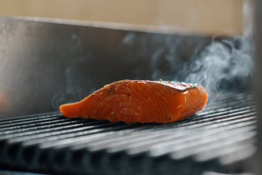 Bir otel restoranında profesyonel bir mutfak. Izgarada taze somon balığı var.