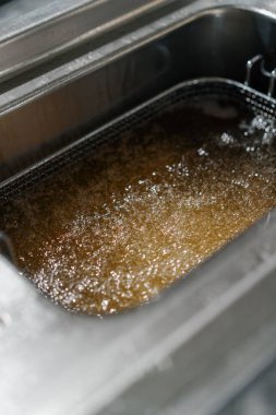 Otel restoranındaki profesyonel mutfak kızartmalar için kızgın yağ.