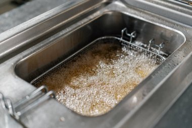 Otel restoranındaki profesyonel mutfak kızartmalar için kızgın yağ.