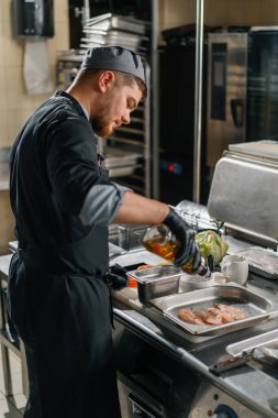 Otel restoranında profesyonel mutfak. Şef kulüp sandviçi için tavuk hazırlar.