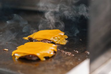 Profesyonel mutfak otel restoranı. Kapalı kapaklı ızgara peynirli burger konsepti.