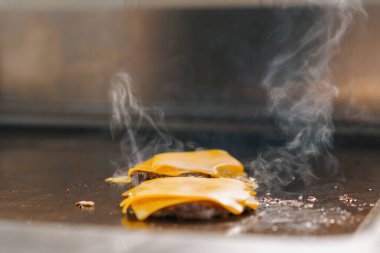 Profesyonel mutfak otel restoranı. Kapalı kapaklı ızgara peynirli burger konsepti.