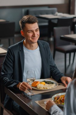 Otel restoranında buluşacağız. Şarap ve lezzetli yemek getiren adam gülecek.