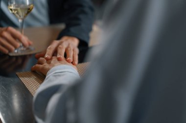 Otel restoranında el ele tutuşan bir çift.