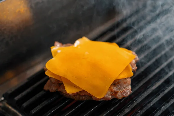ホテルのレストランでプロのキッチンでチーズ焼きのバーガーパティ — ストック写真