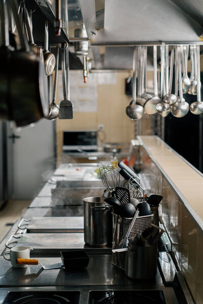Professional kitchen in the hotel restaurant dishes ladles hang on hood