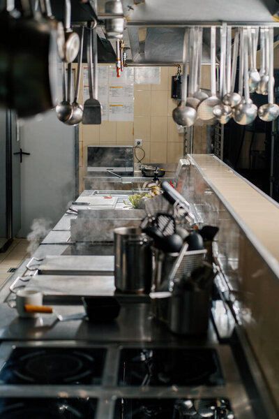 Professional kitchen in the hotel restaurant dishes ladles hang on hood
