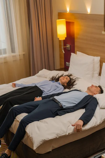 couple on bed luxury hotel interior Romantic couple lying on bed in hotel suite Handsome man and woman enjoying vacation
