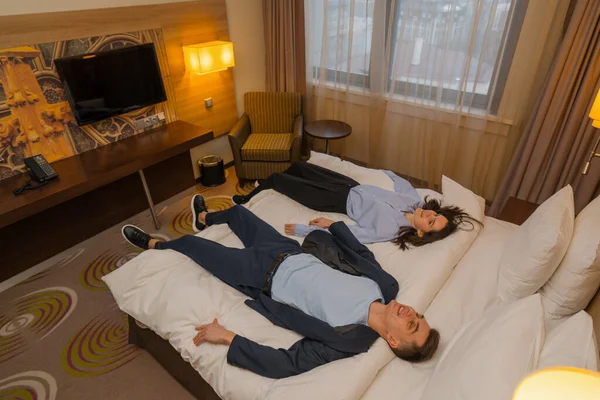couple on bed luxury hotel interior Romantic couple lying on bed in hotel suite Handsome man and woman enjoying vacation