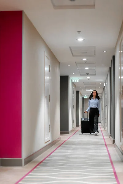 Dziewczyna Walizką Idzie Korytarzem Hotelowej Bizneswoman Wycieczkę Pojęcie Podróży — Zdjęcie stockowe