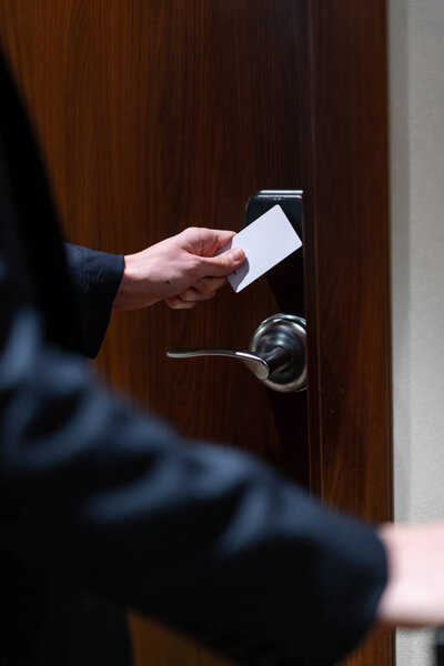 A man with a suitcase opens the door of a hotel room a businessman on trip travel concept