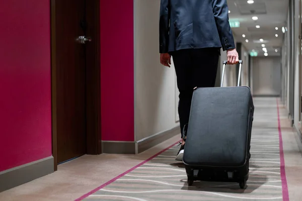 Ein Mann Mit Einem Koffer Läuft Den Hotelflur Hinunter Eine — Stockfoto