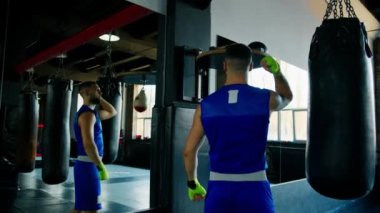 Boks salonunda kum torbasıyla hız egzersizi yapan bir boksör.