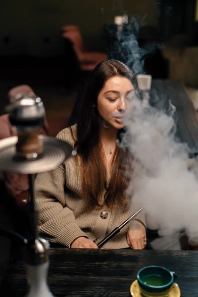 美しい若い女性吸入フカ女の子喫煙フカ座ってラウンジバーのコンセプトリラクゼーションと喫煙 — ストック写真