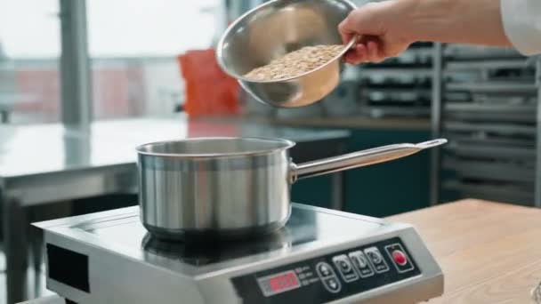 Επαγγελματική Κουζίνα Σεφ Χύνει Πλιγούρι Βρώμης Κατσαρόλα Για Μαγείρεμα Πρωινό — Αρχείο Βίντεο