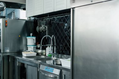 Profesyonel reklam boş modern mutfak restoranda metal mutfak ekipmanları batıyor.