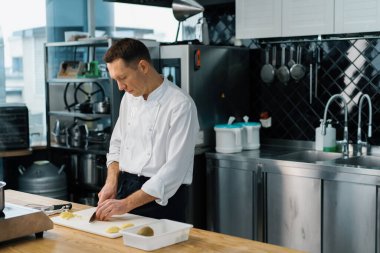 Profesyonel şef bıçakla meyve kesiyor. Yulaf ezmesi kahvaltısı hazırlıyor. Sağlıklı gıda konsepti.