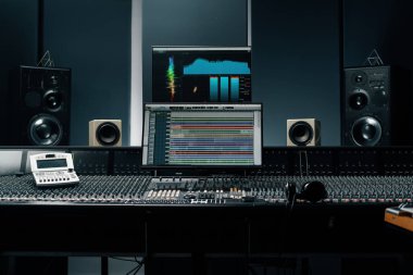Ses dalgası ve ses ayarları olan bir ekran ile kayıt stüdyosu iki subwoofer ve karıştırma konsolu