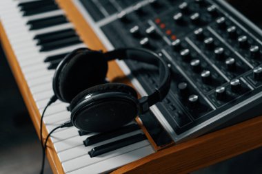 Kulaklıklar elektronik bir klavyede durur. Kayıt stüdyosunda bir şarkı oluşturan bir stüdyo konsepti.