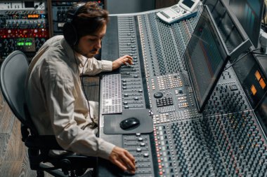 Ses mühendisi müzik stüdyosunda çalışıyor. Monitörler ve ekran karıştırma ve ana parçalarla.