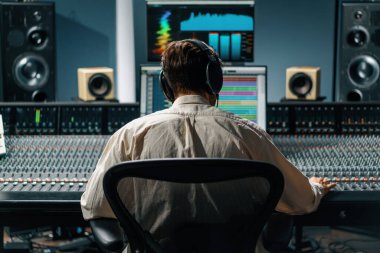 Ses mühendisi müzik stüdyosunda çalışıyor. Monitörler ve ekran karıştırma ve ana parçalarla.