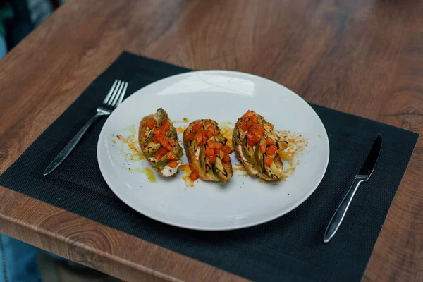 焼きたてのアボカドとトマトをテーブルの上のレストランで食べる健康的な食事の概念 — ストック写真