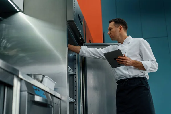 Modern Mutfak Pişirme Konseptinde Çalışırken Tablet Bilgisayar Tarifleri Kullanan Profesyonel — Stok fotoğraf