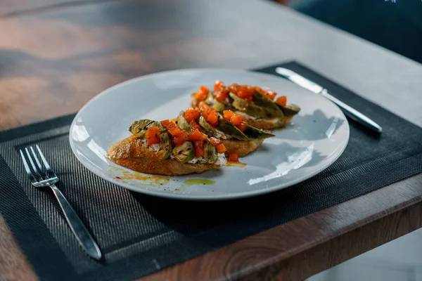 焼きたてのアボカドとトマトをテーブルの上のレストランで食べる健康的な食事の概念 — ストック写真